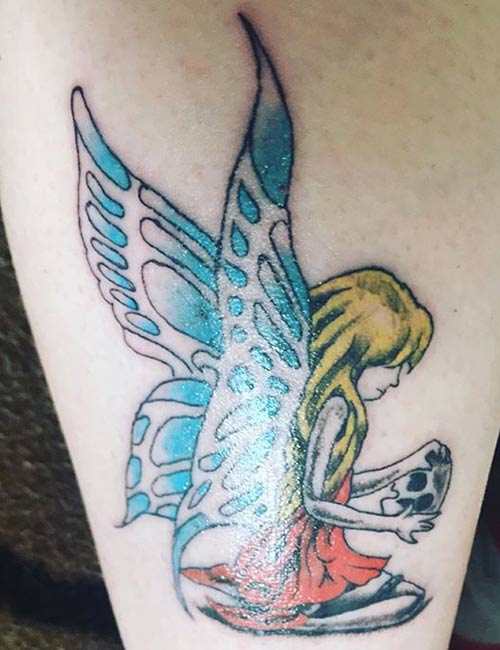 Color tattoo of a seated pixie
