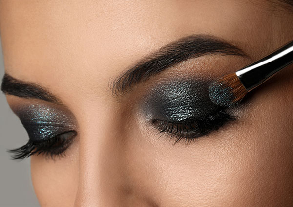 Applying dark eyeshadow with a smokey brush liner