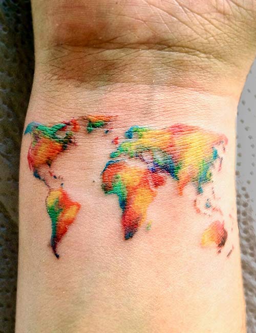 Colored tatttoo of the world on the wrist represnting love for travel