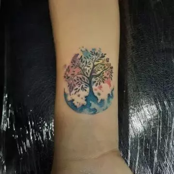 Watercolor moon and tree tattoo on the wrist