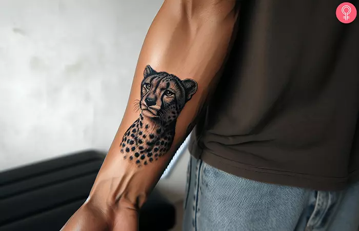 A black and gray cheetah tattoo on the forearm