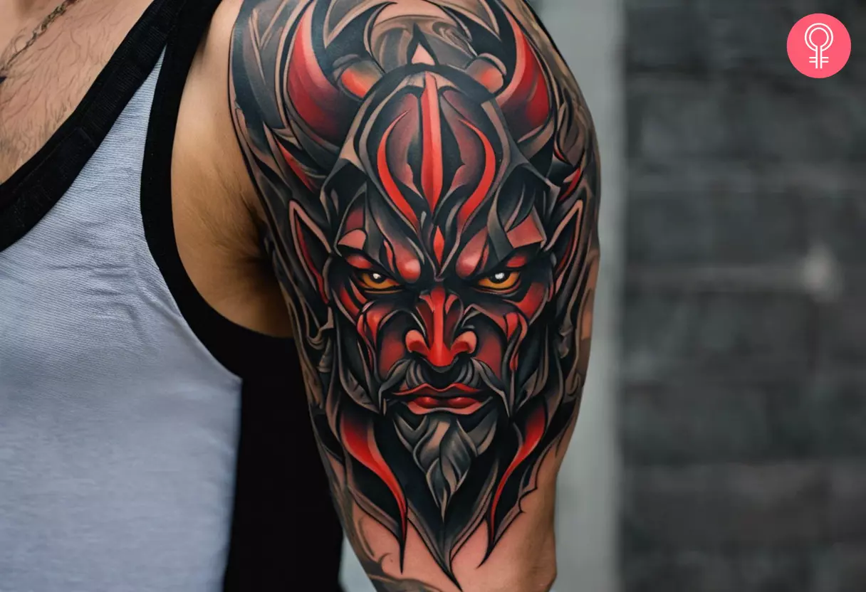 A devil face tattoo on the upper arm