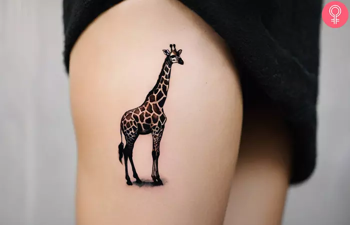 A mini giraffe tattoo on the thigh