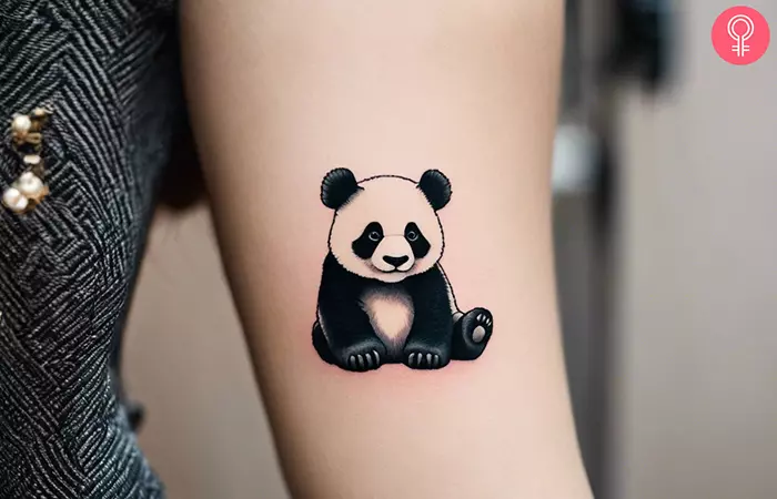 A panda tattoo on the upper arm