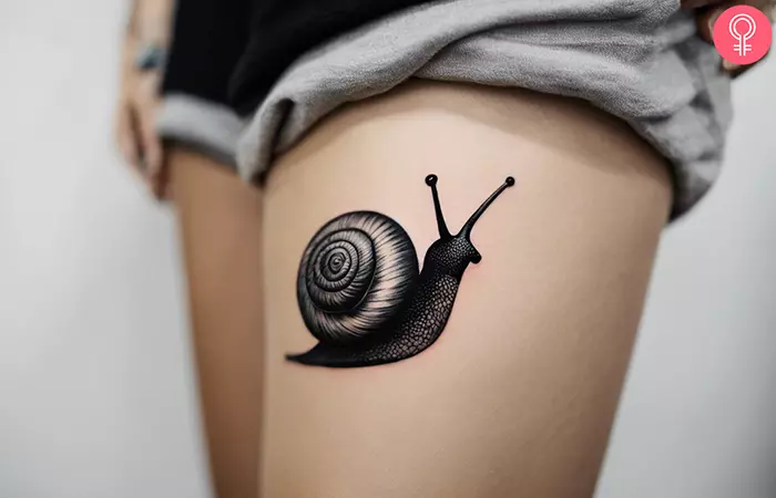 A snail tattoo on the thigh