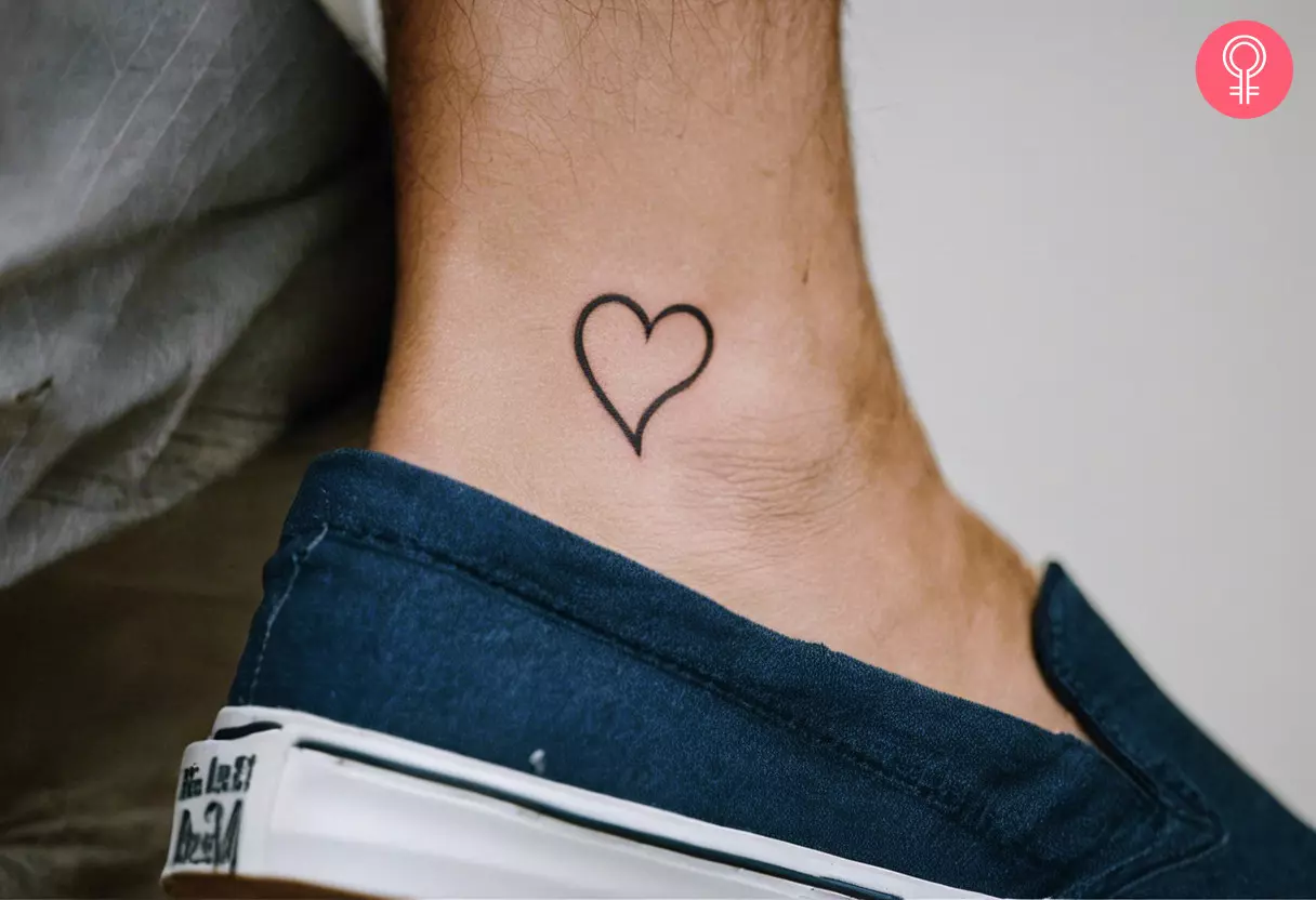 A woman with a fine-line heart tattoo on their ankle