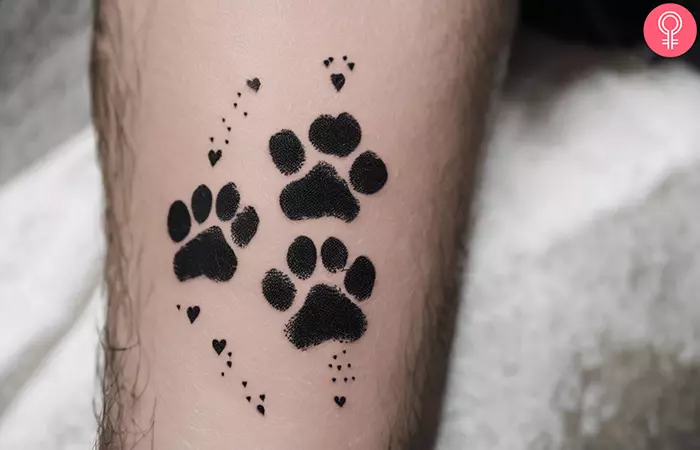 An animal lover tattoo featuring pawprints and tiny hearts