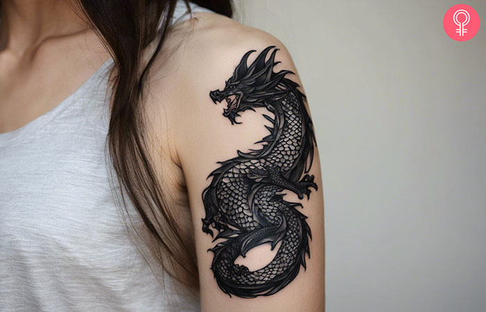 A woman with a black dragon tattoo on her upper arm.
