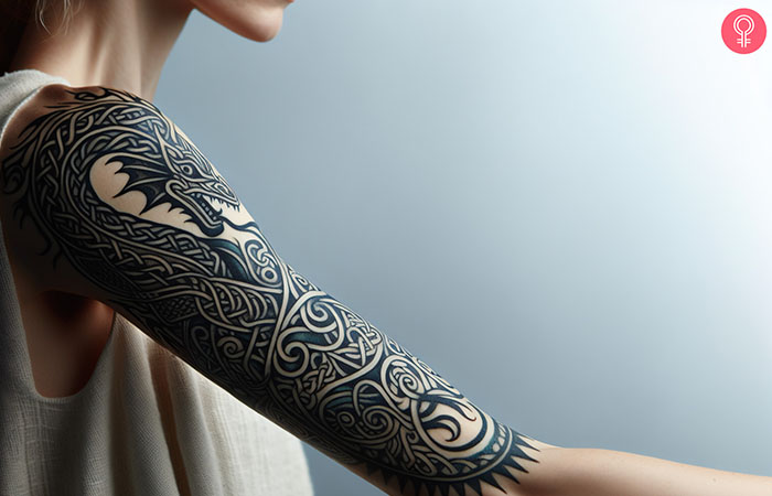 A woman with a Celtic dragon tattoo on her upper arm.