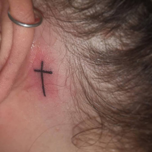 Cross tattoo behind the ear