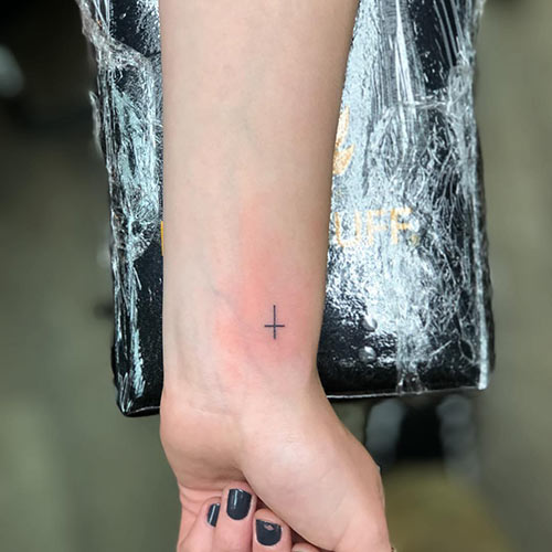 Cross tattoo on the wrist for a minimalist look