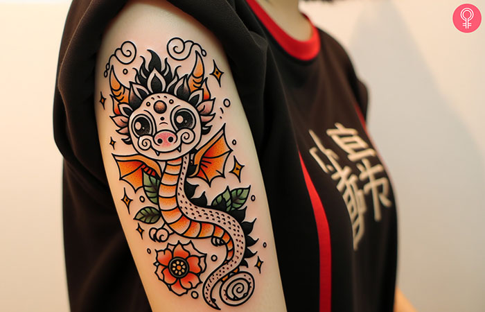 A woman with a colorful cute dragon tattoo on her upper arm.