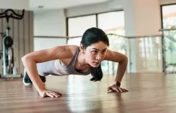 A woman doing pushups in the gym.