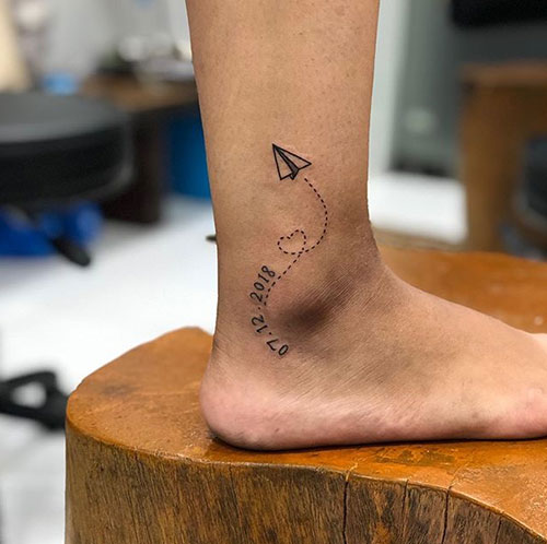 Paper plane ankle tattoo