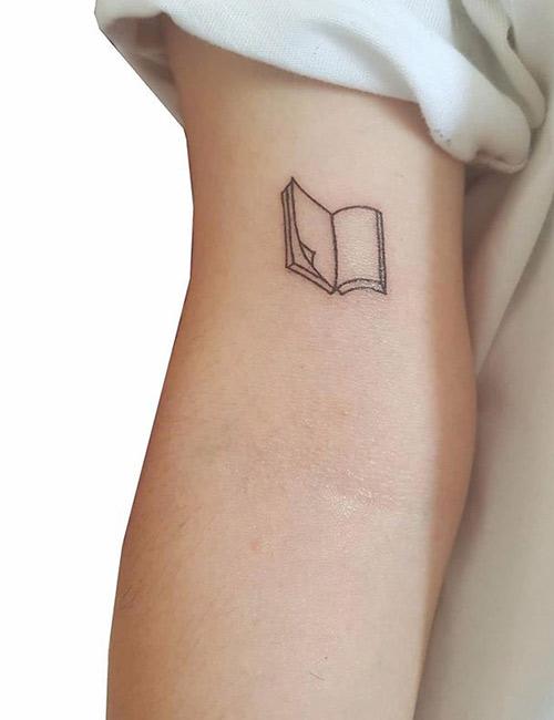 Minimalist book tattoo on the wrist