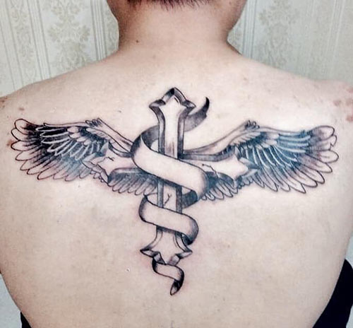 Winged cross tattoo on the back