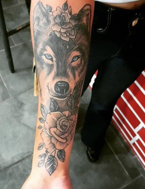 Tatuagem de lobo e rosas no braço