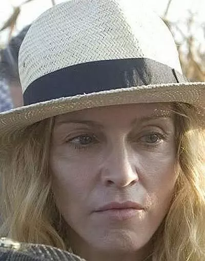 Madonna without makeup wearing a white sun hat