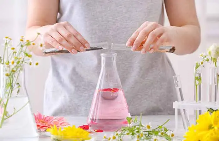 A woman preparing perfume in flasks