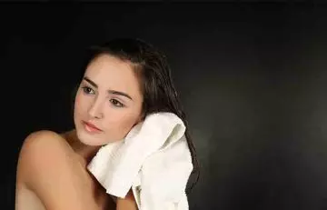 Woman squeezing out excess water from hair