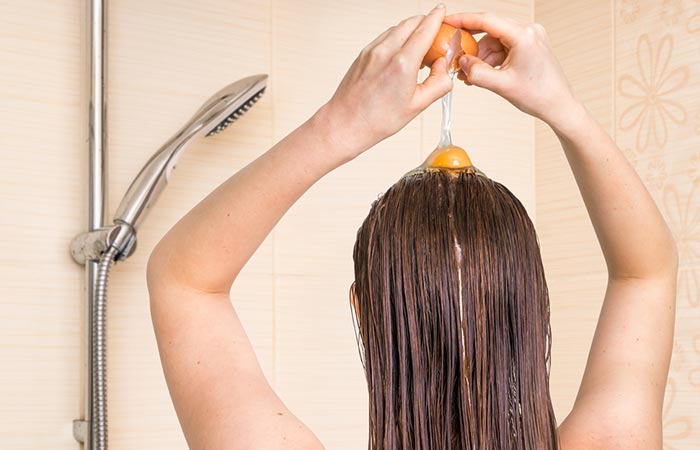 Woman applying egg yolk on her hair