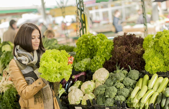 Woman selecting fresh lettuce in the farmer's market