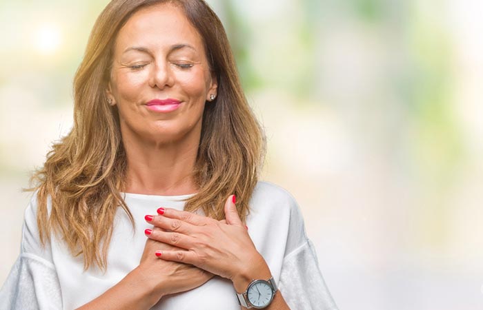 Woman smiling with her hands on her chest implying a healthy heart
