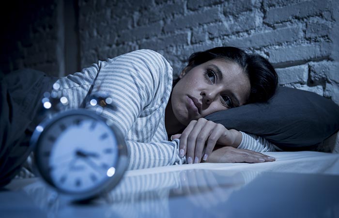 Woman laying awake in bed late in the night