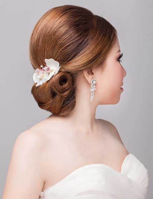 Slight pompadour twist bun bridal hairstyle for round face