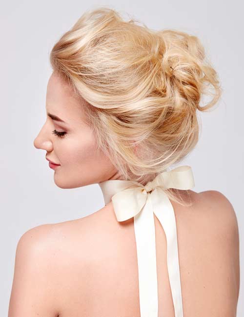 Loose messy bun bridal hairstyle for round face