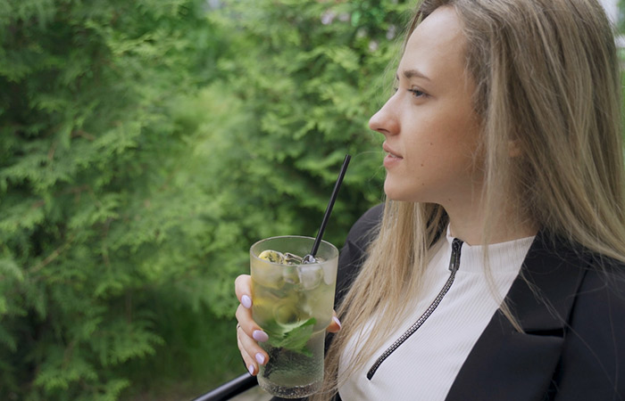 Woman drinking lime and basil drink for its antiviral properties
