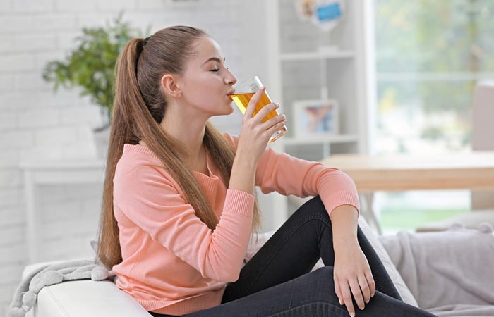 Woman drinking apple juice for glowing skin