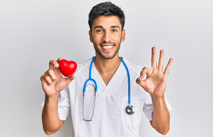 Doctor holding model of heart to convey good heart health