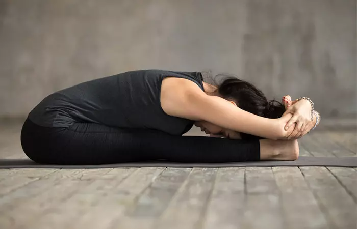 Young woman practicing paschimottanasana