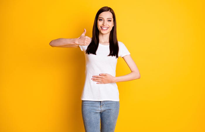 Woman with one hand on belly to portray good digestive health