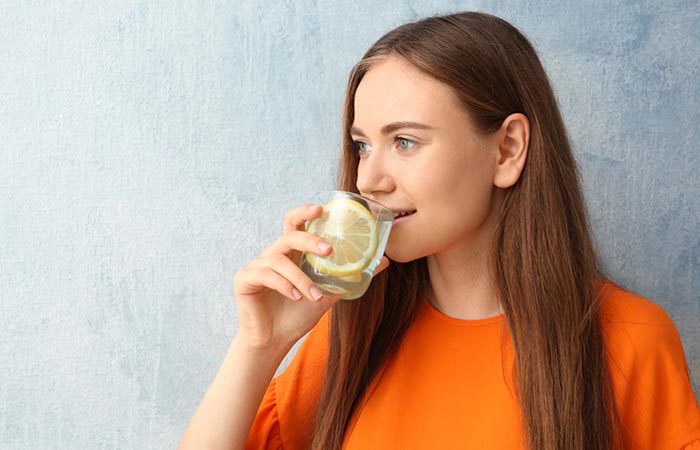 Woman drinking lemon juice for glowing skin