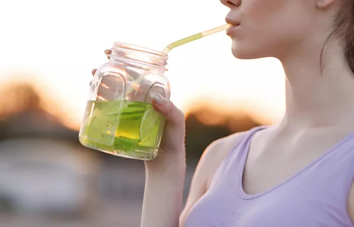 Woman drinking fresh lime water for glowing skin