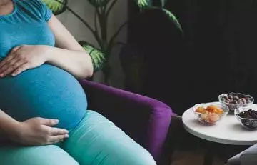 Pregnant woman with a bowl of apricots