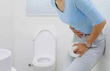 Woman with constipation in the washroom