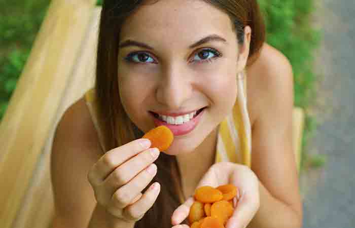 Top shot of woman eating apricot