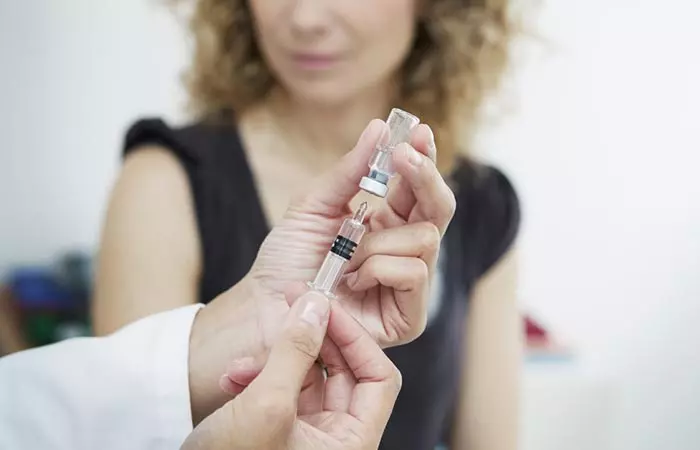 Doctor prepares cortisone shot.