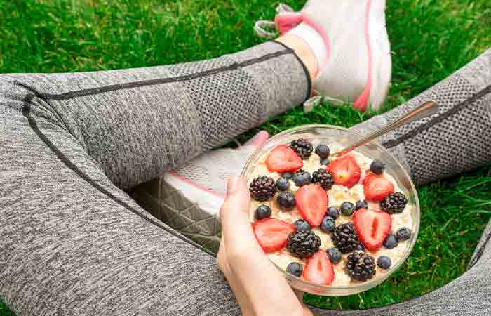 Woman holding a bowl of cereal topped with strawberries