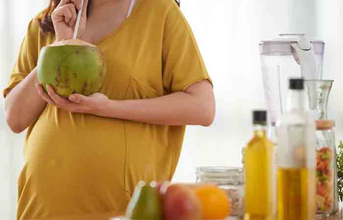 Pregnant woman drinking coconut water