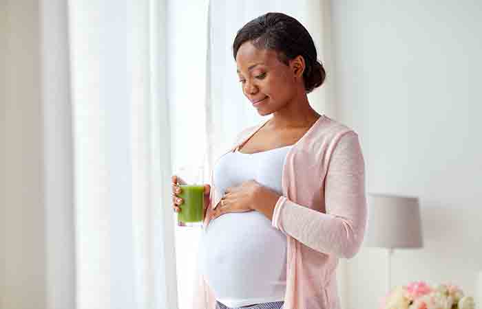 Pregnant woman having spinach juice
