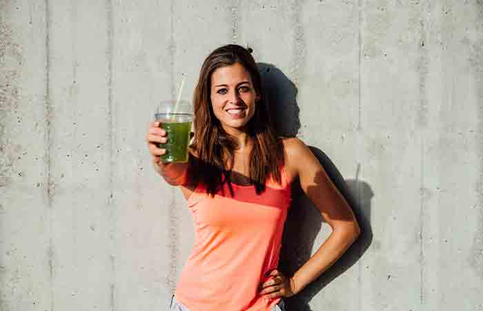 Woman holding a sipper of spinach juice