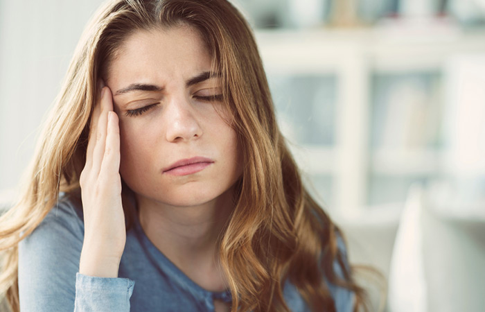 Woman having headache for excess garlic consumption