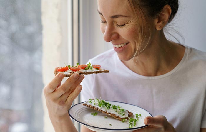 Woman eating snacks with fenugreek sprouts for healthy hair