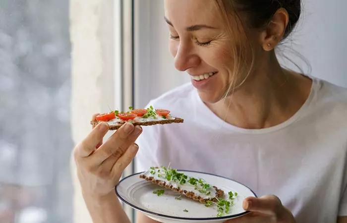 Woman eating snacks with fenugreek sprouts for healthy hair