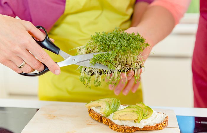 Woman chopping fenugreek sprouts for anti-aging benefits