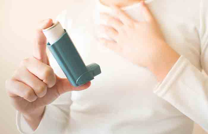 Asthmatic woman using her inhaler